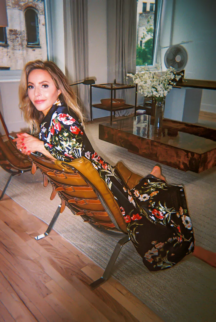 Gabby Bernstein on a chair facing the back of the chair